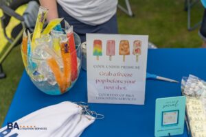 B&A Litigation Services freeze pop station with "Cool Under Pressure" sign at the TPCBA golf tournament