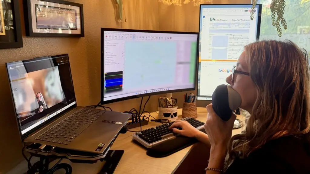 B&A court reporter Holly Christiansen voice writing a remote deposition with a stenomask at her workstation