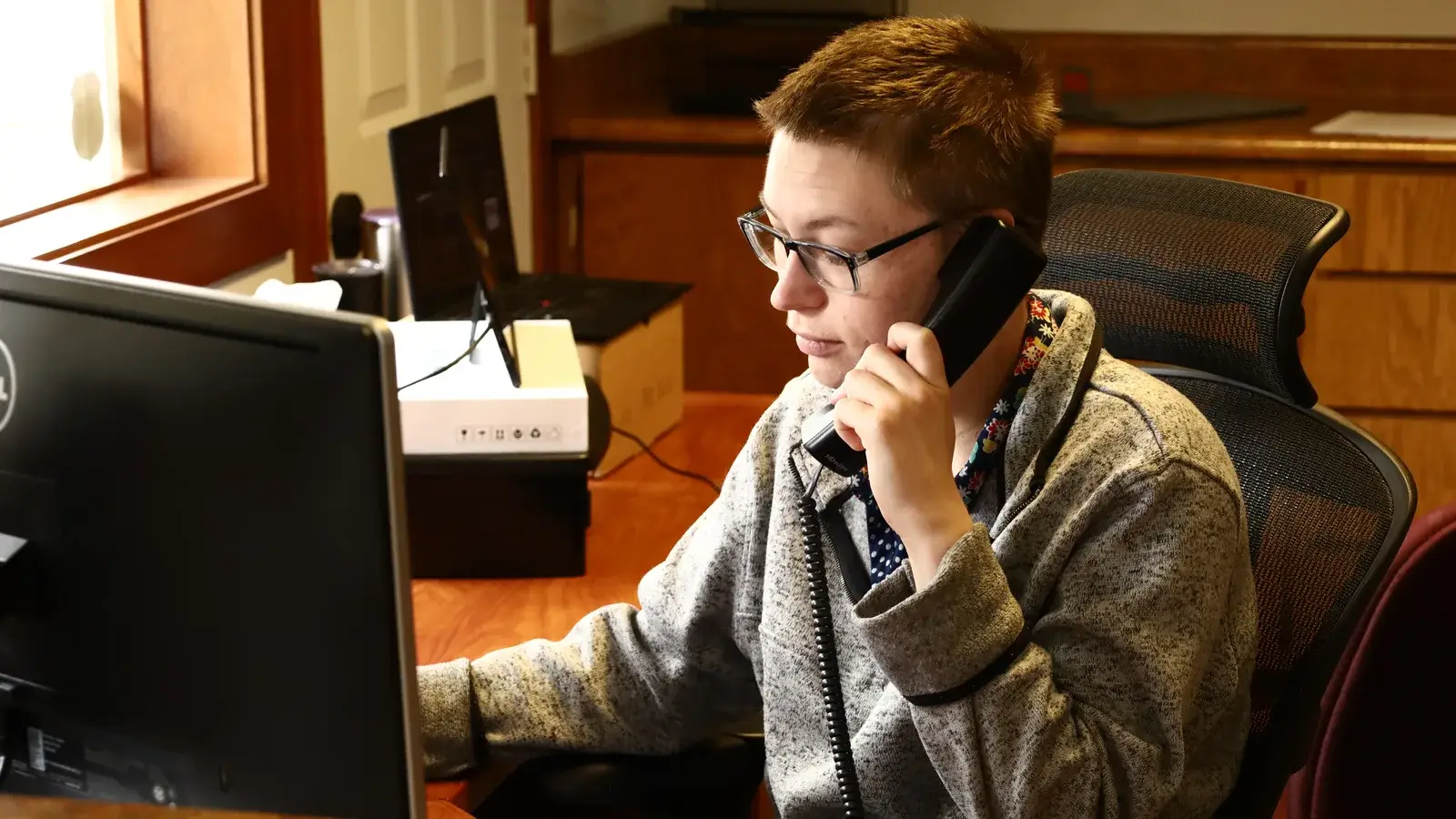 A B&A scheduler on the phone at a desk