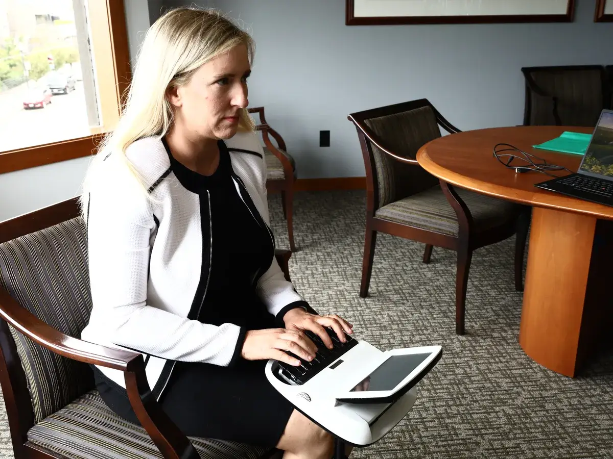 Co-owner Sarah Fitzgibbon at the stenotype machine beside the table in a B&A Tacoma conference room