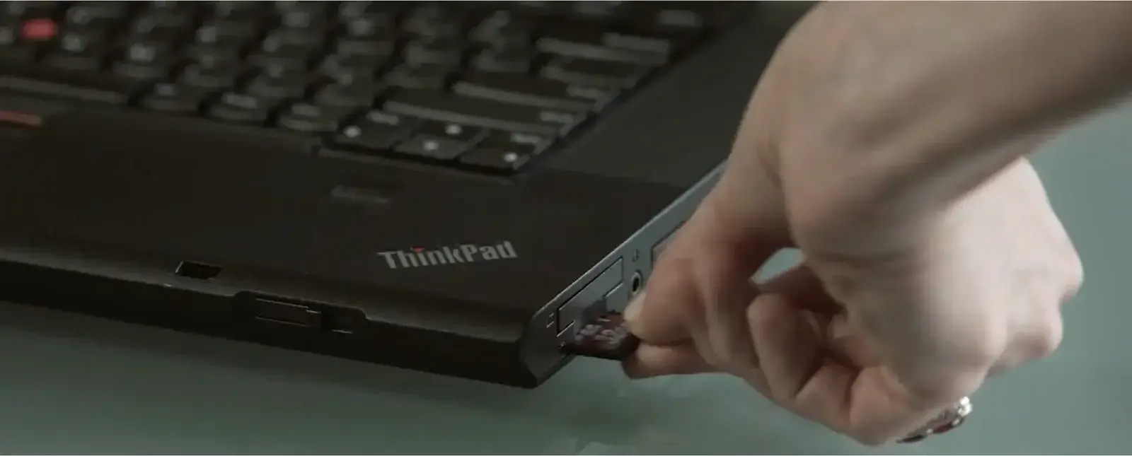 Hand connecting a cable to a laptop