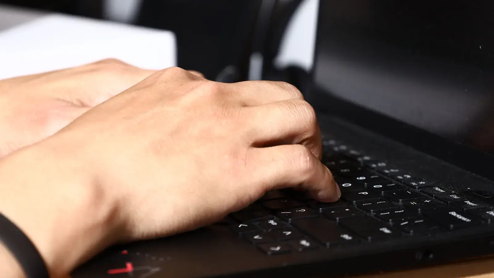 Hands typing on a laptop keyboard